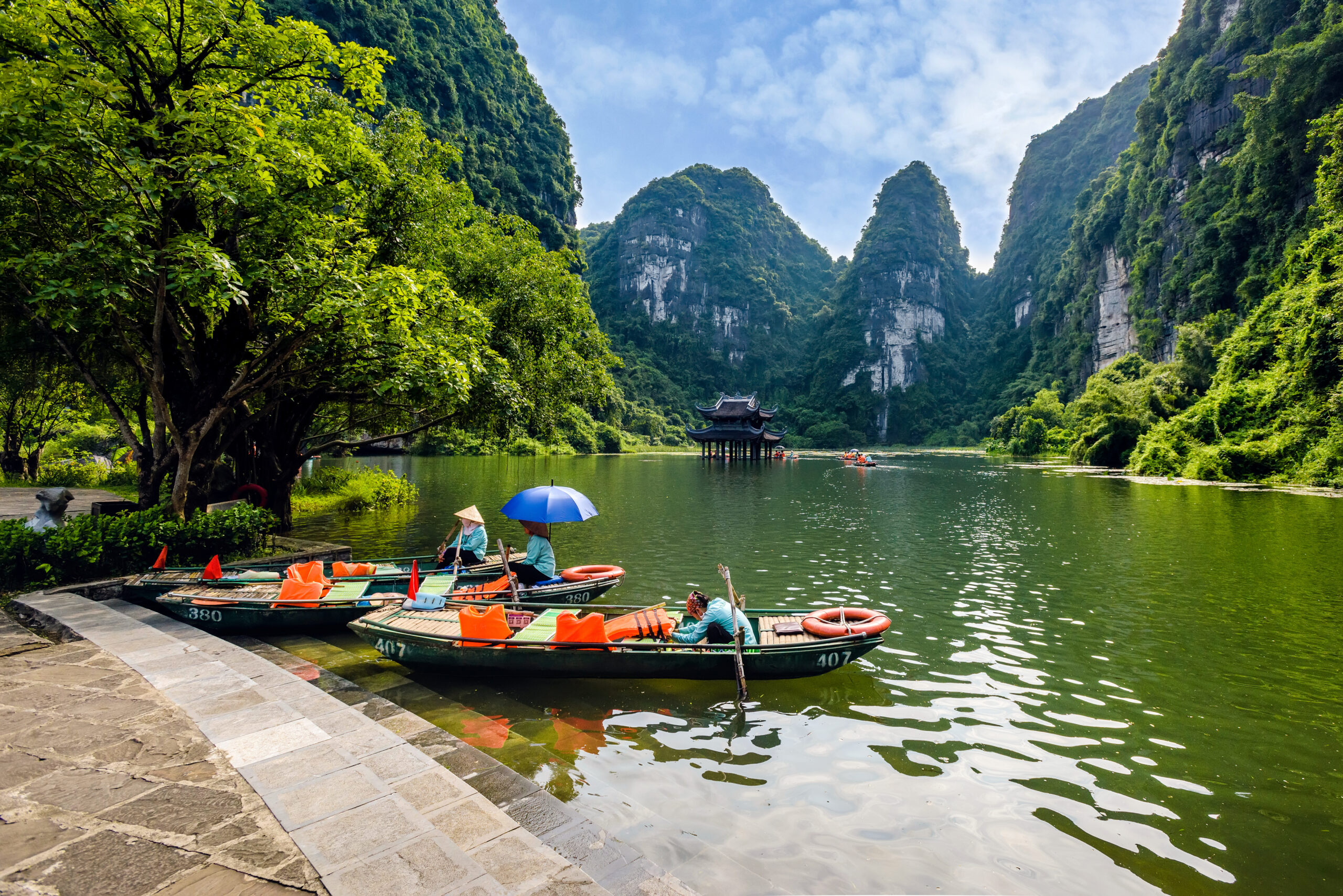 rowing boats docked on shore of Trang An, Ninh Binh province, Vietnam
