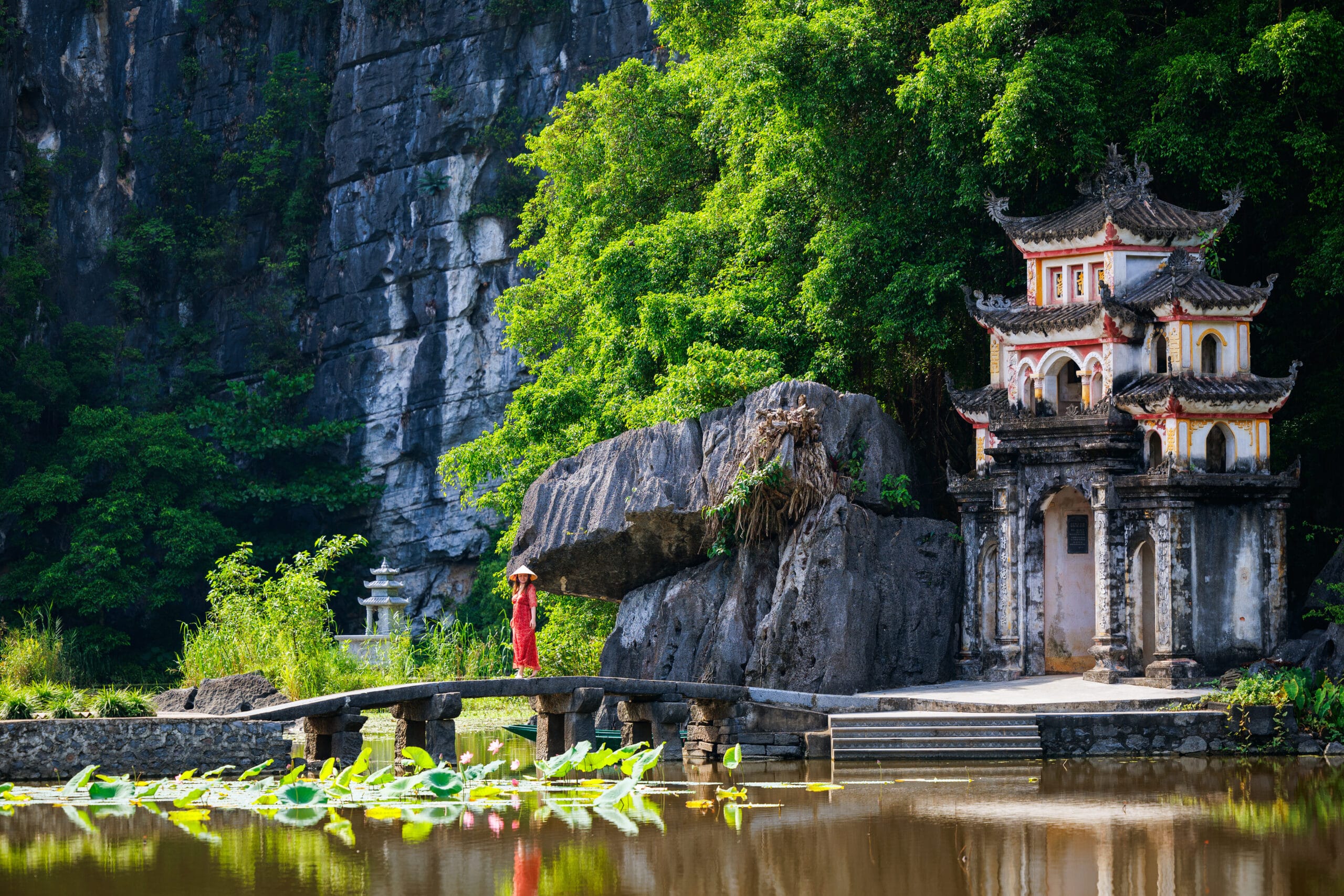 woman wearing ao Dai on bridge of Bich Dong Pagoda
