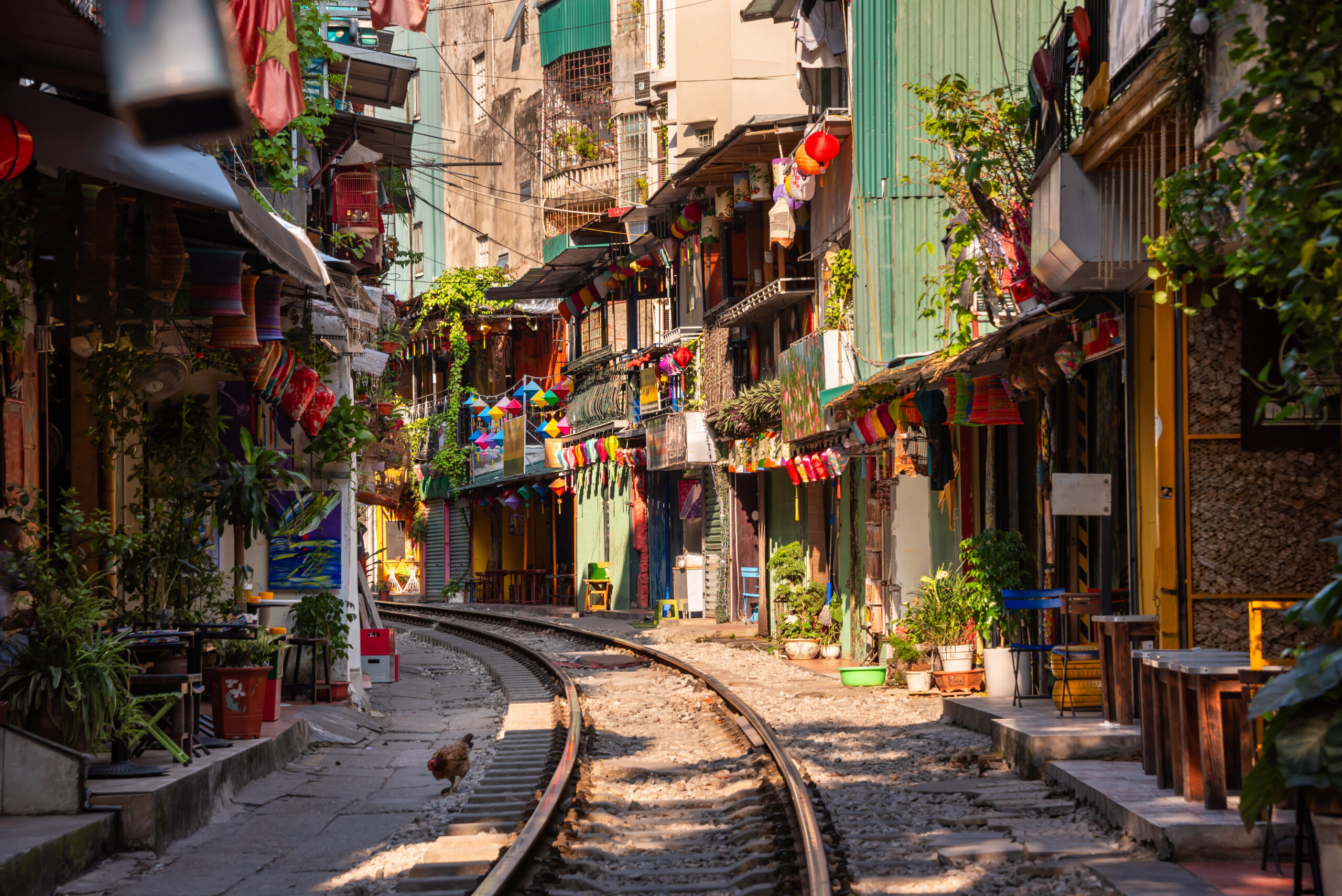railroad tracks surrounded by homes and buildings on either side to the track. Tourism spot in Ha Noi, Vietnam