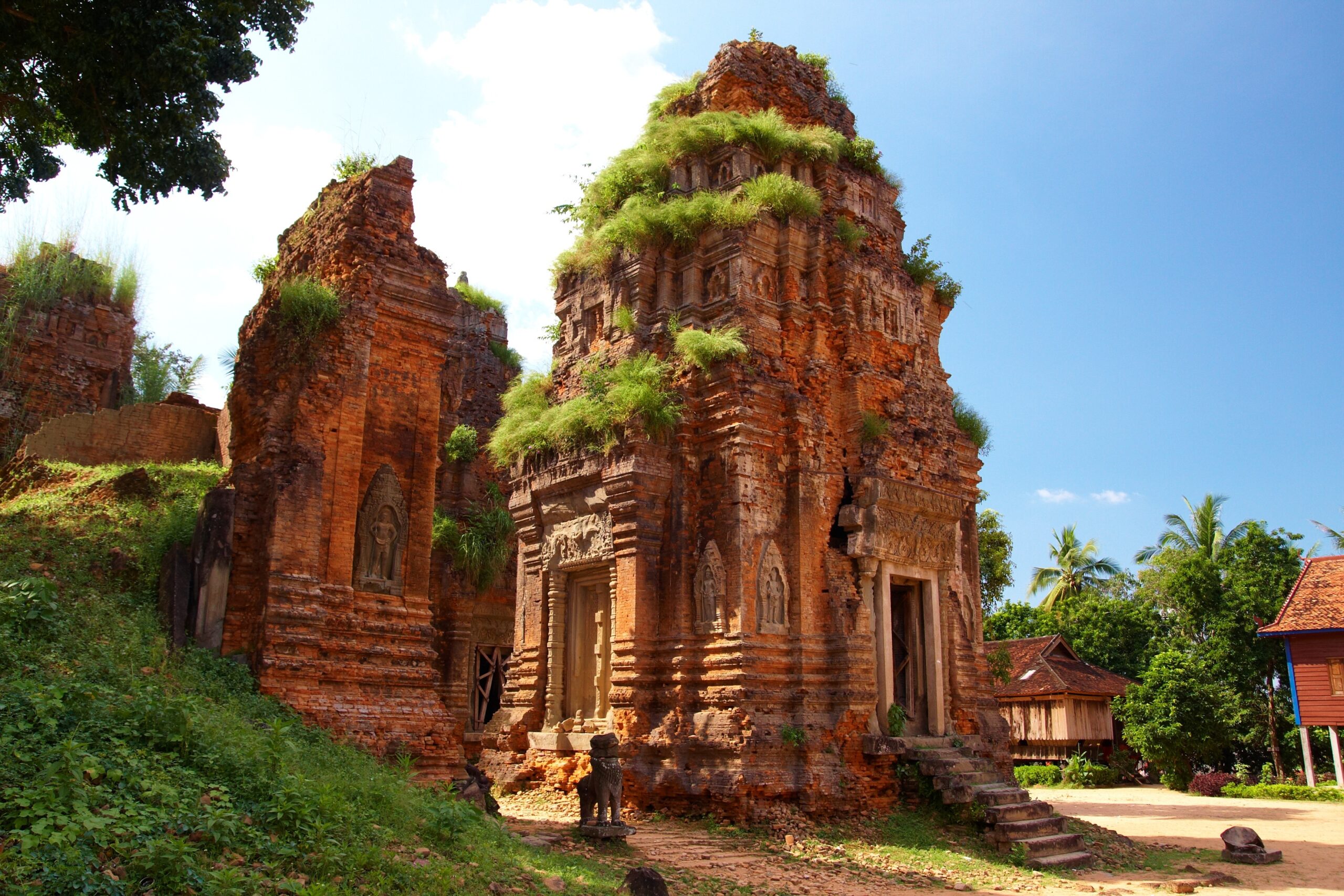 side view of Angkor Wat Rolous Group with overgrown grass growing on top of building