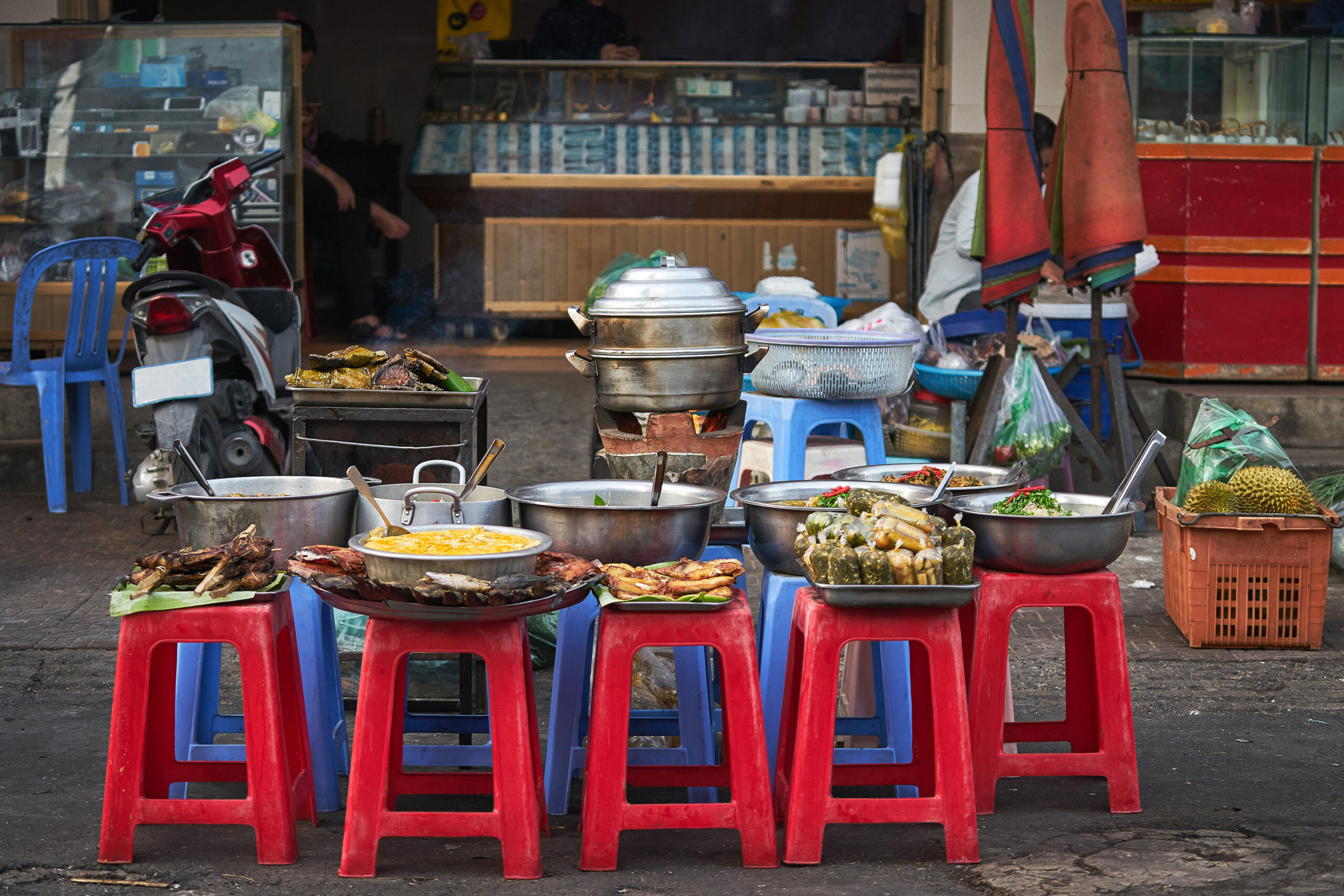 large pots and bowls of food placed on plastic chairs