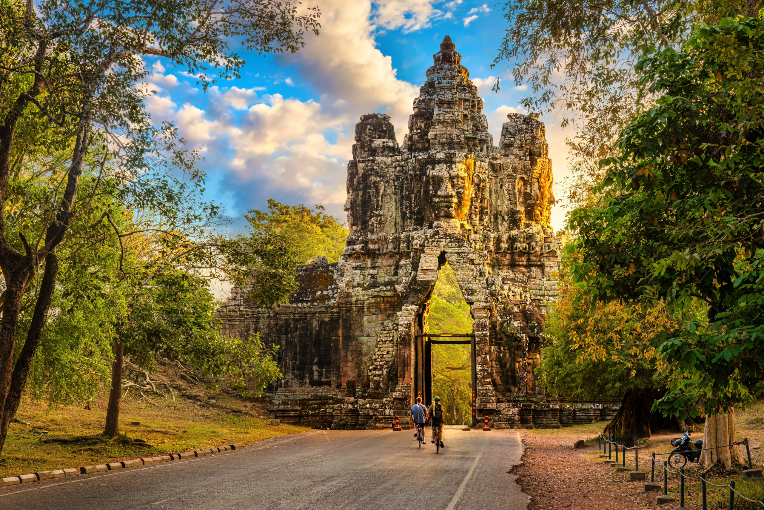 2 bikers biking through Angkor Thom South Gate Angkor Wat Complex