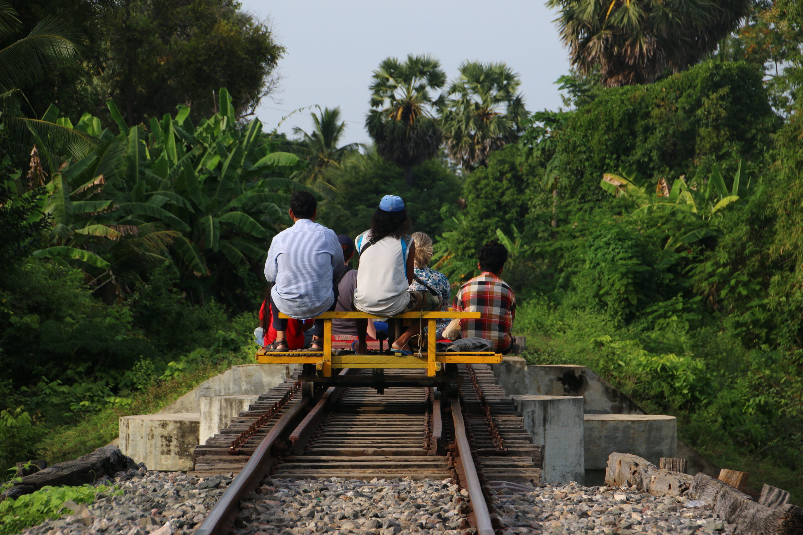 back view of locals riding on the bamboo train in Battambang