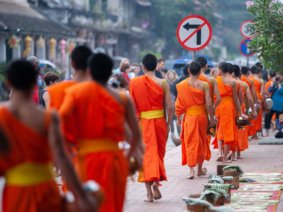 AdobeStock_240137416 Alms Giving in Luang Prabang monks collecting offerings at sunrise
