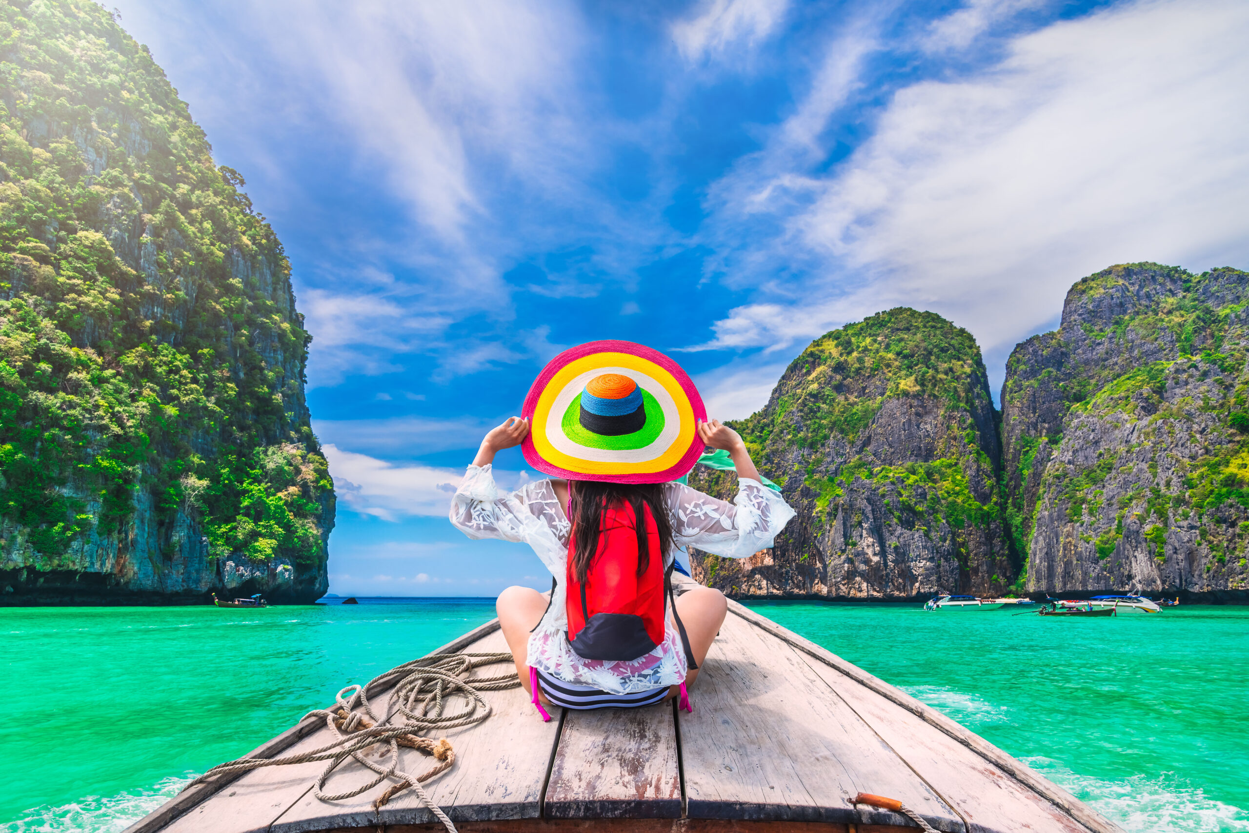Colorful summer lifestyle traveler woman joy fun relaxing on boat at sunny beach Maya bay Krabi, Tourist girl on holiday vacation trip in Phuket, Thailand